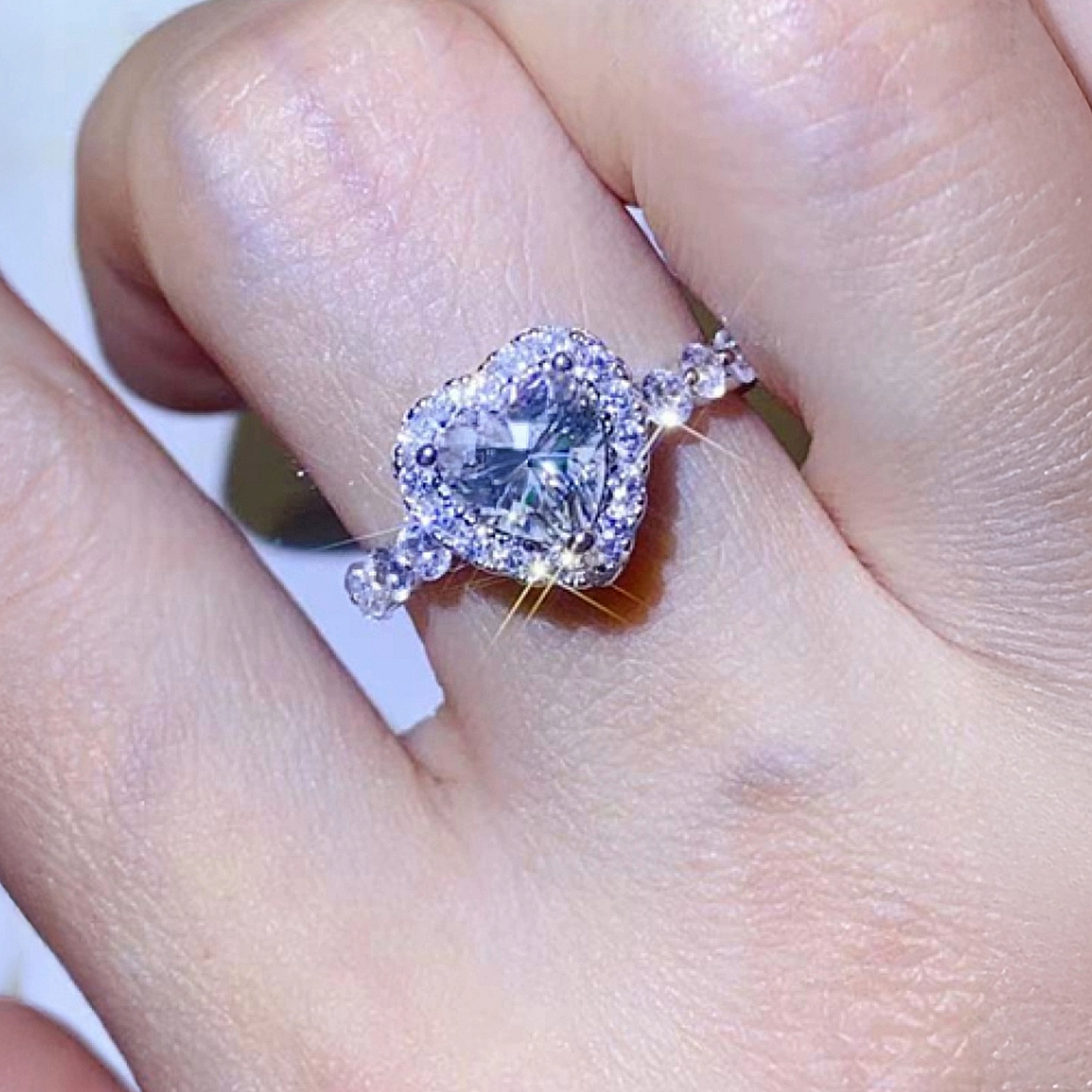 Diamond ring on a finger with a blurred background