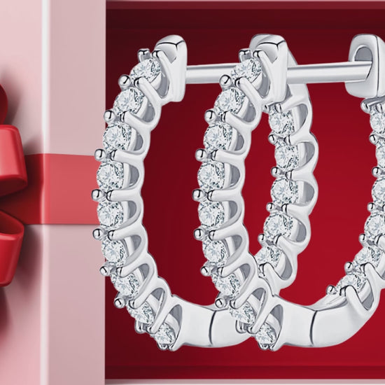 Silver moissanite hoop earrings on red gift bakground.