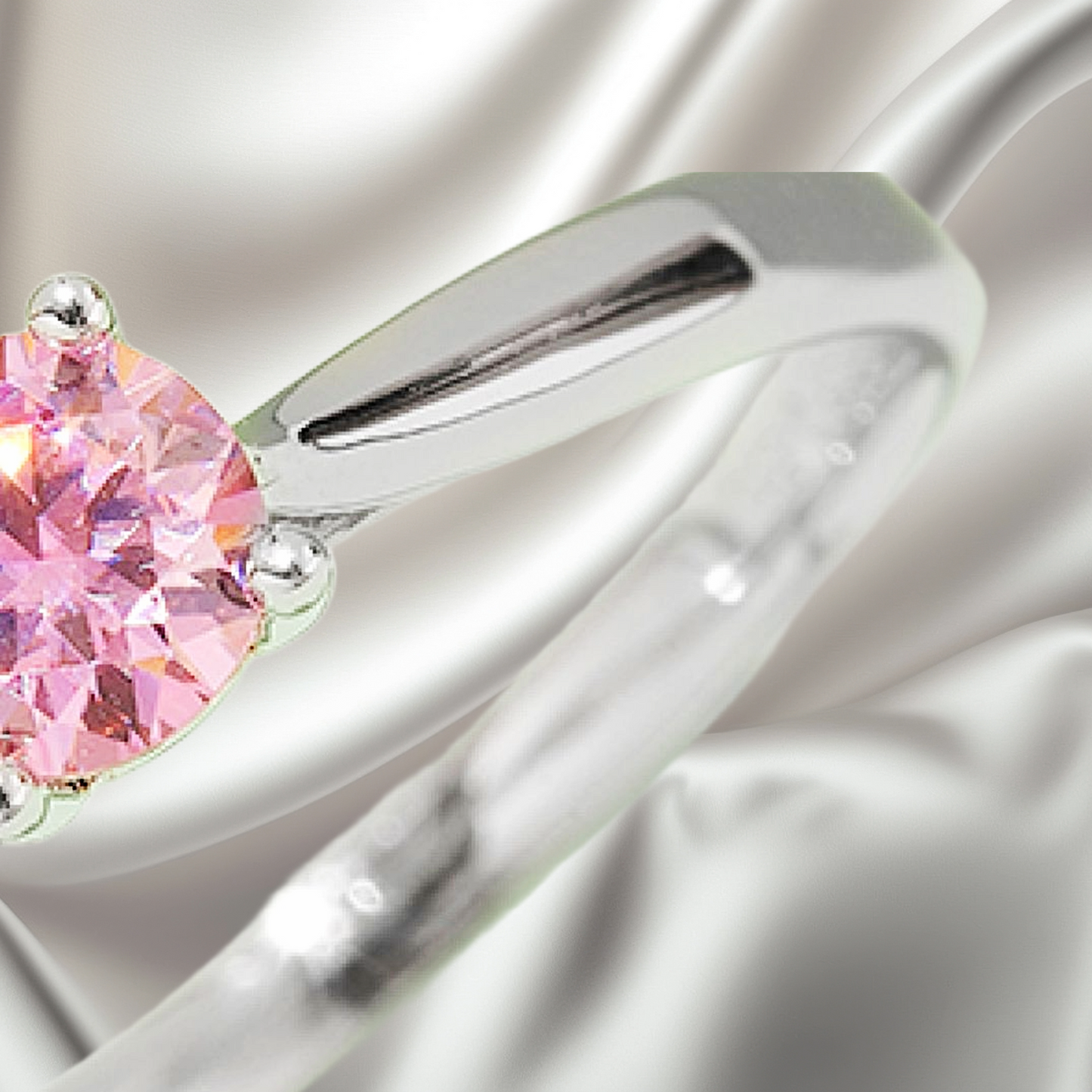 Silver ring with a pink gemstone on a white satin background