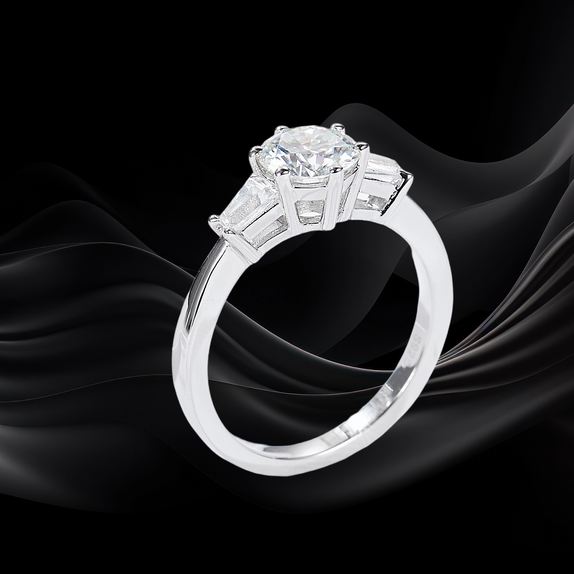 Diamond ring with three-stone design on a black fabric background