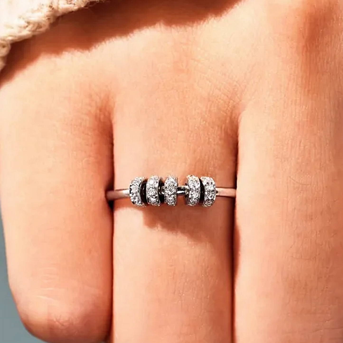 Close-up of a silver ring with beads on a person's finger