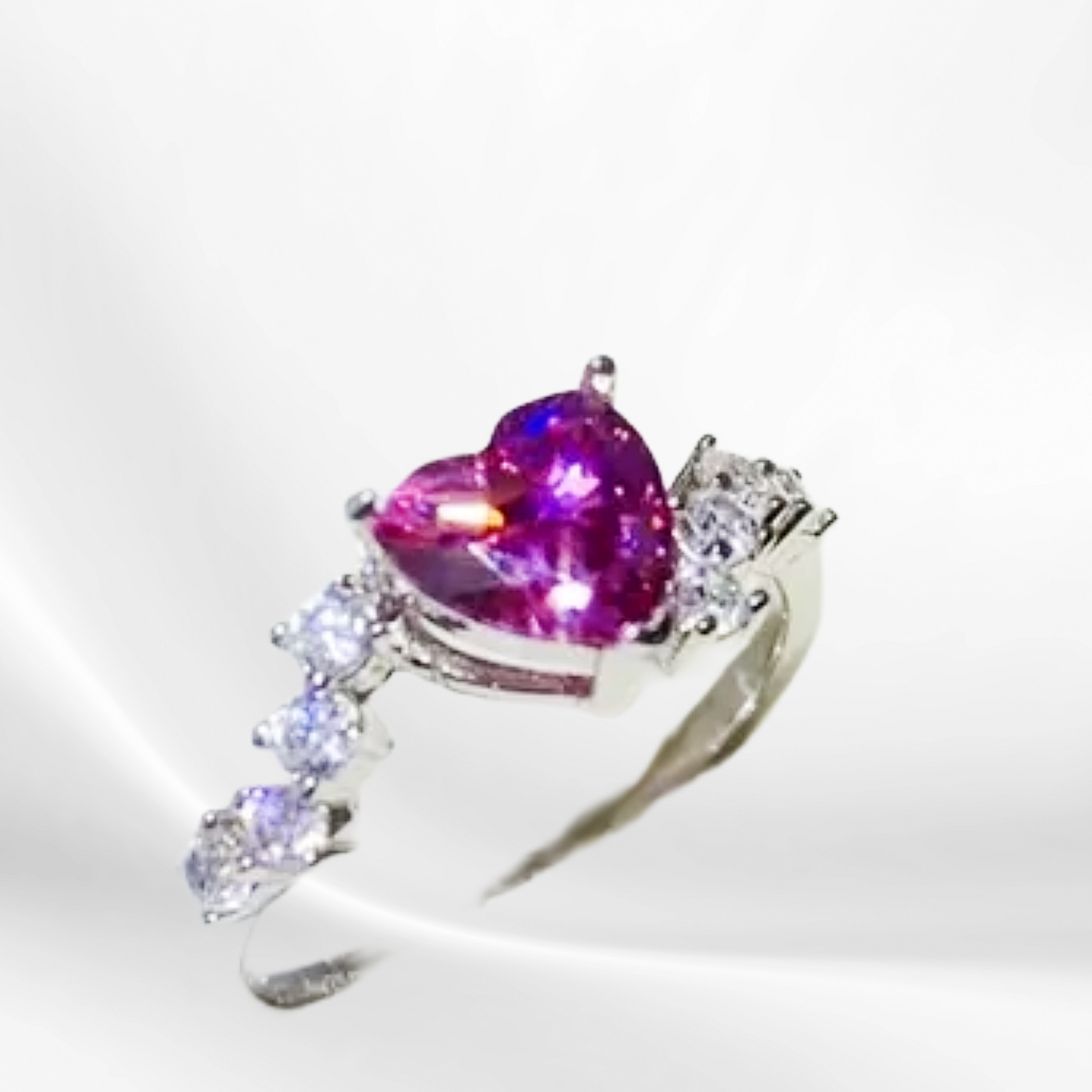 Silver ring with a heart-shaped purple gemstone on a white background