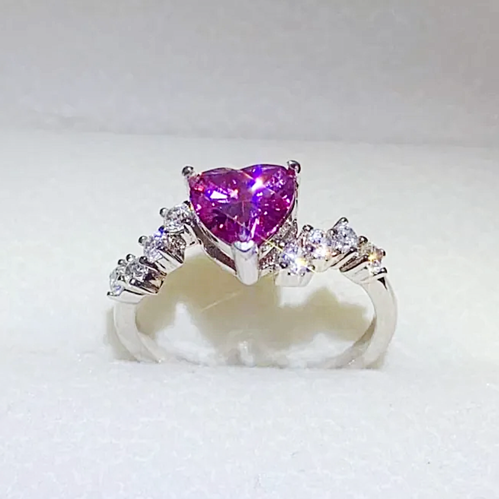 Silver ring with a heart-shaped pink gemstone on a white background