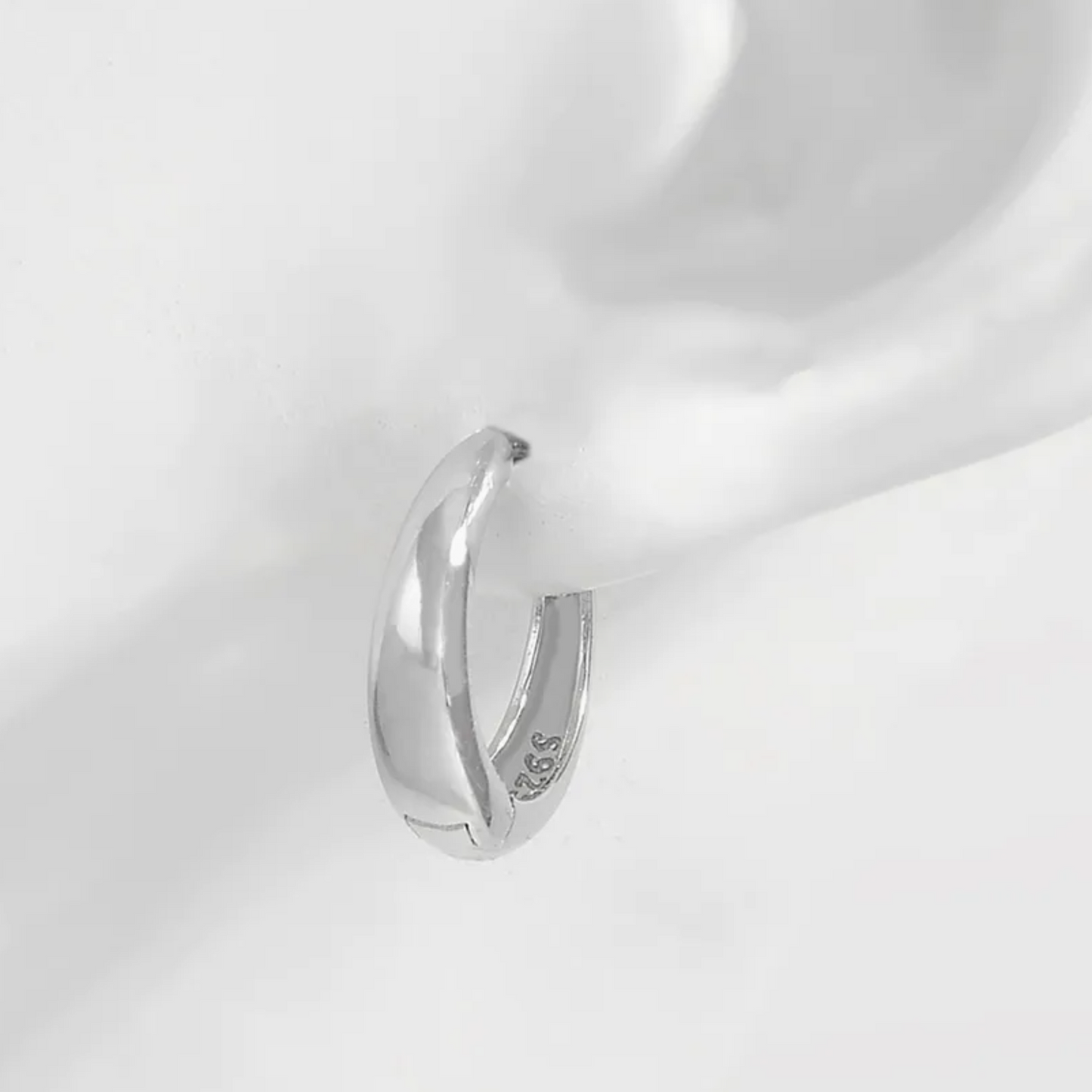 Silver earring on a white background