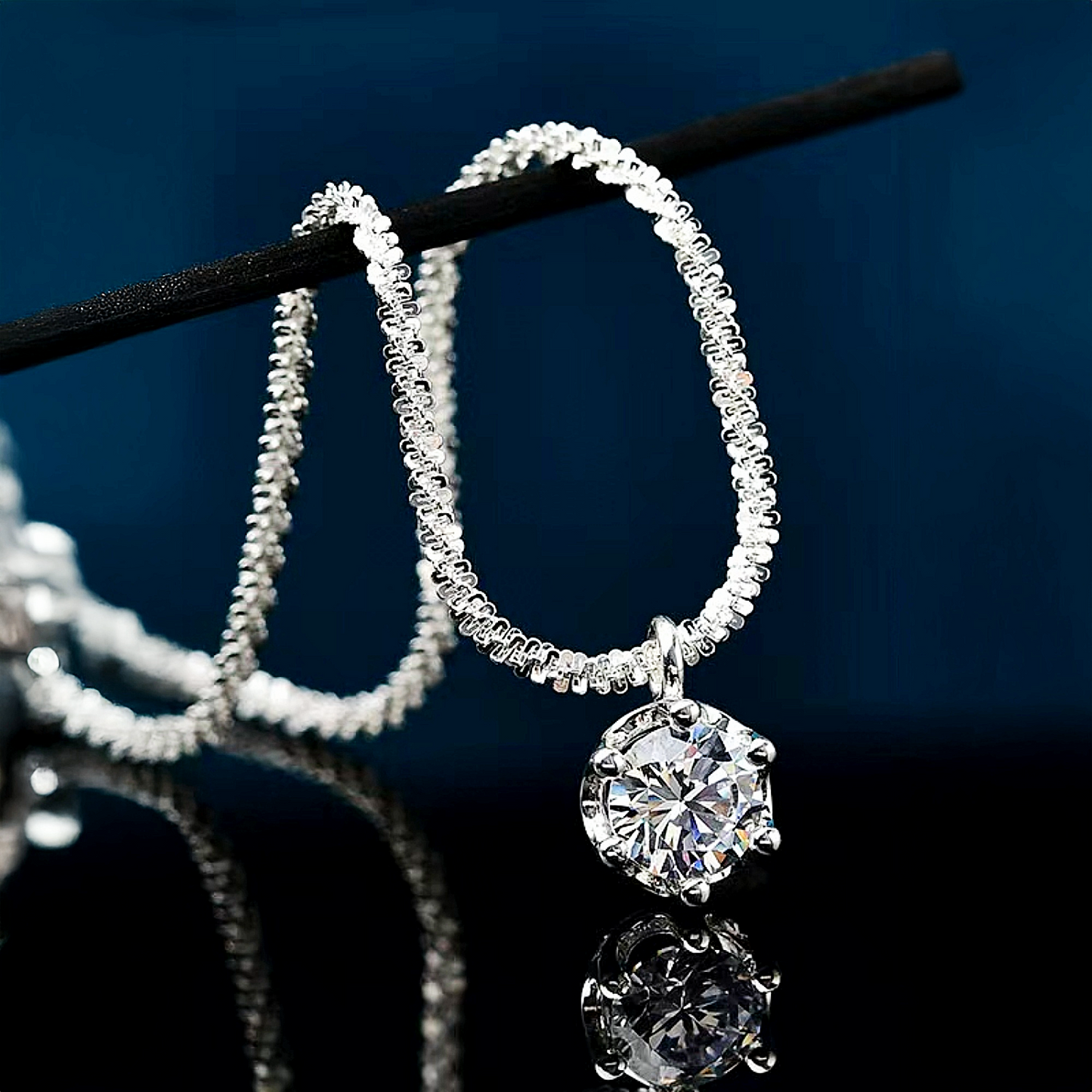 Silver hoop earrings with a central diamond on a dark background