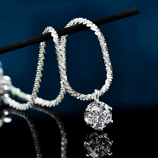 Silver hoop earrings with a central diamond on a dark background