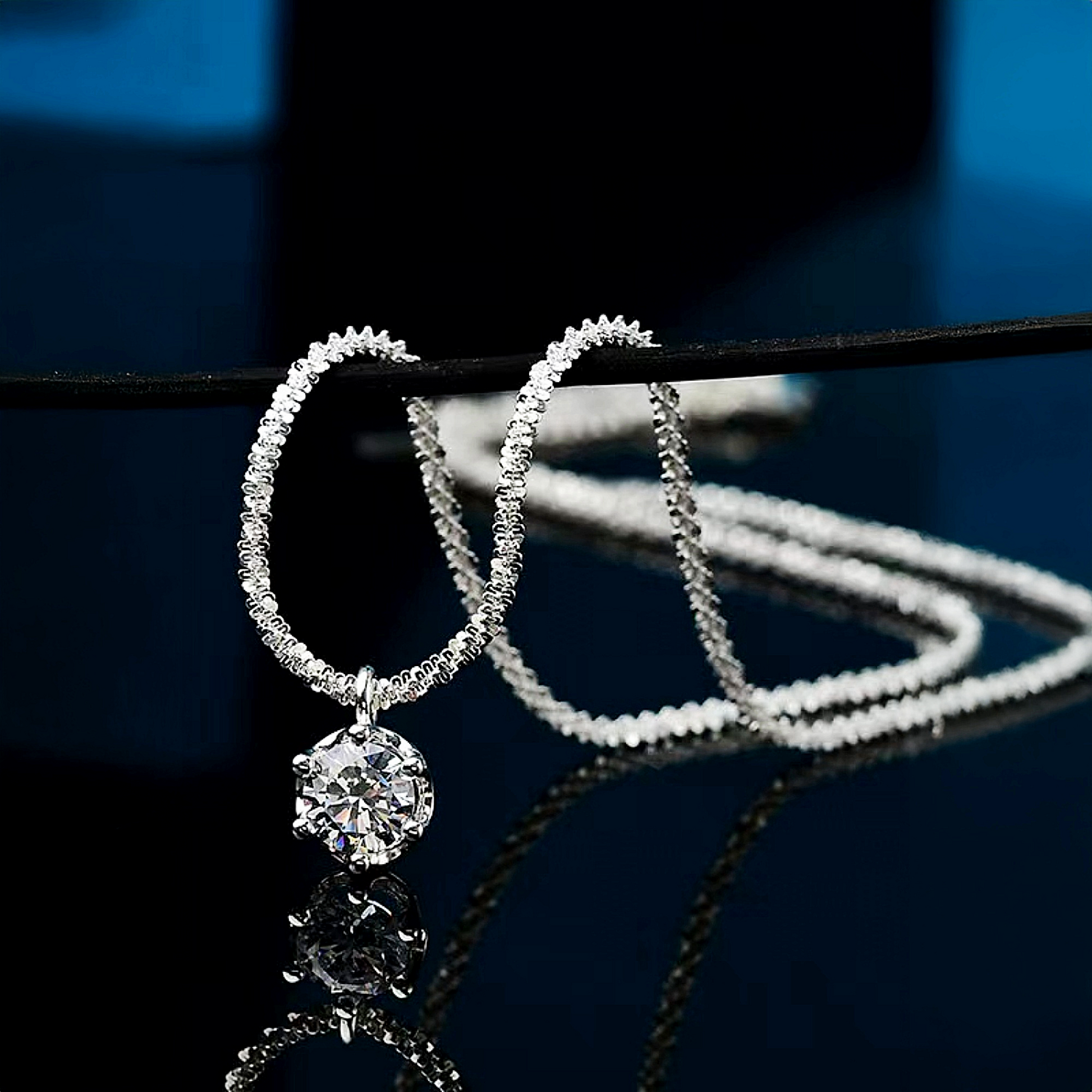 Silver hoop earrings with a central gemstone on a dark background