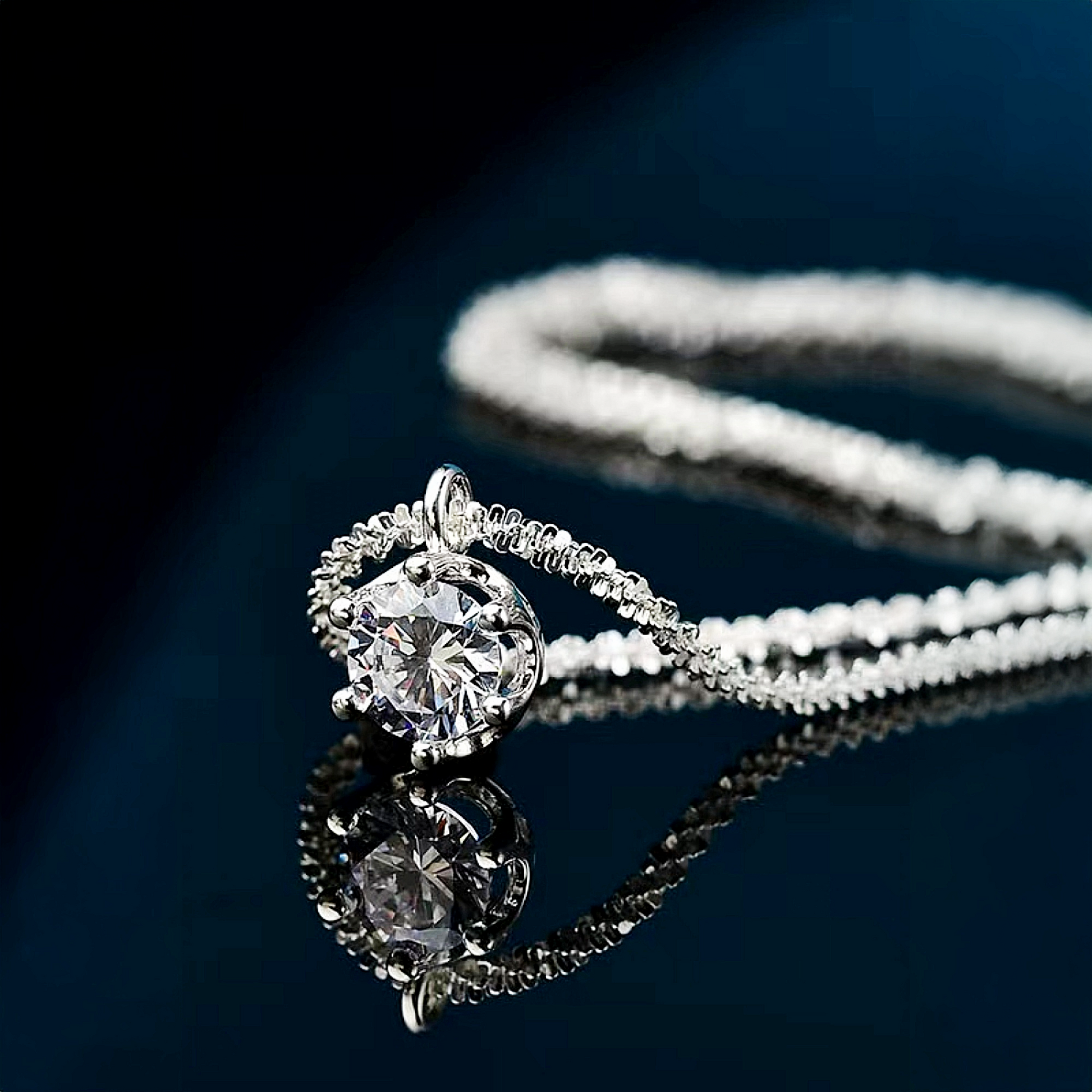 Silver necklace with a diamond pendant on a dark background