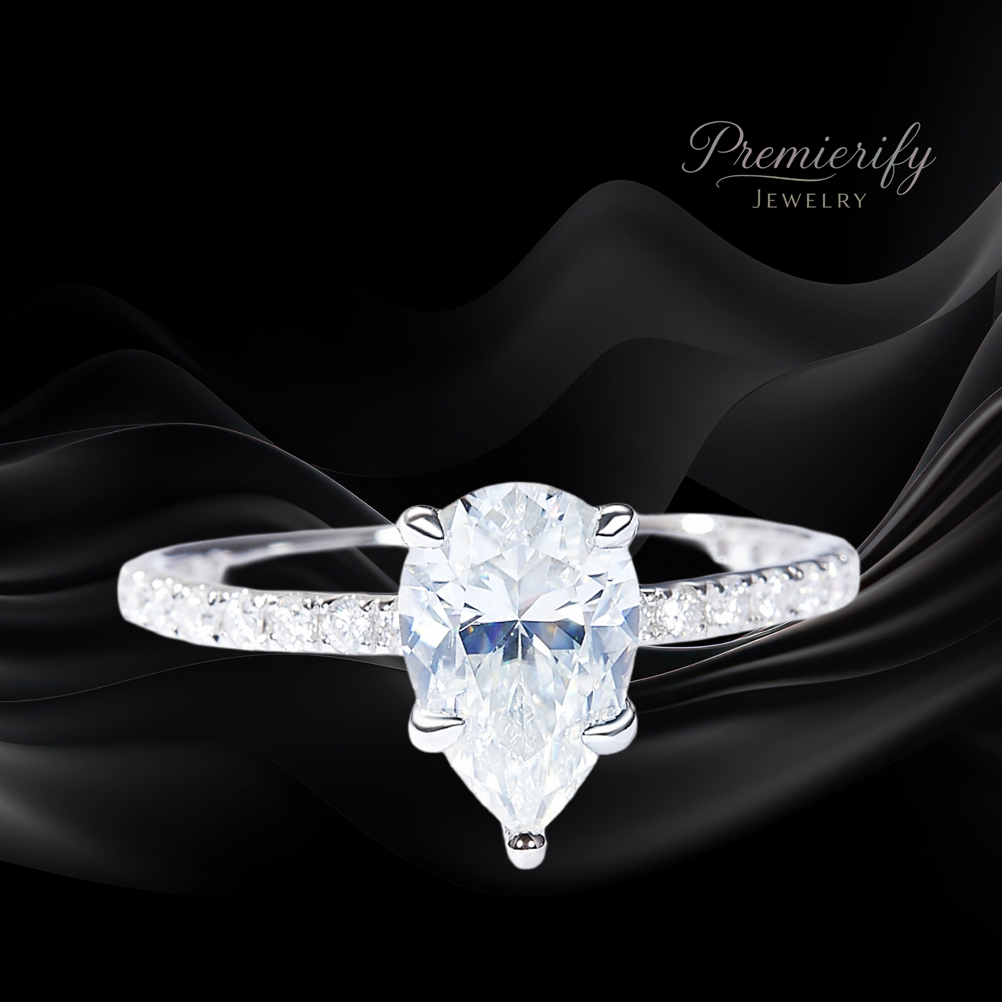 Diamond ring with pear-shaped center stone on black fabric, featuring 'Premierify Jewelry' branding.
