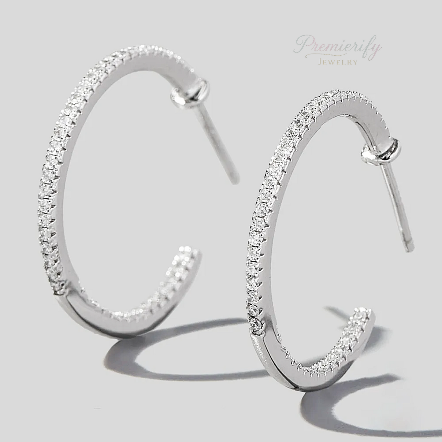 Silver hoop earrings with clear stones on a light gray background, branded 'Premierify Jewelry'.