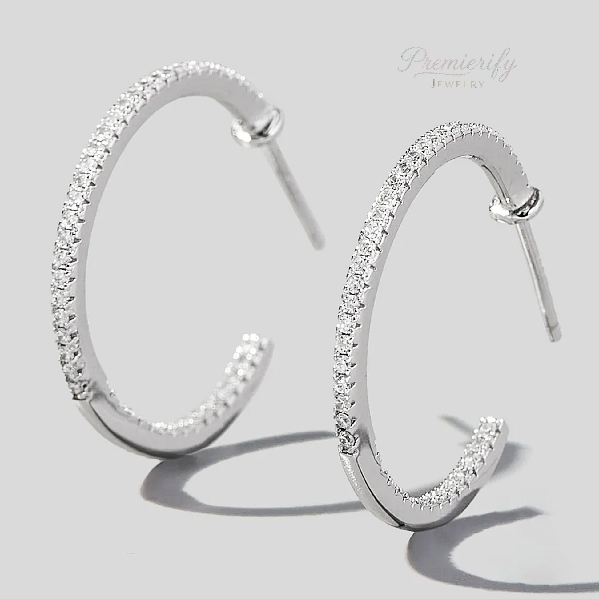 Silver hoop earrings with clear stones on a light gray background, branded 'Premierify Jewelry'.