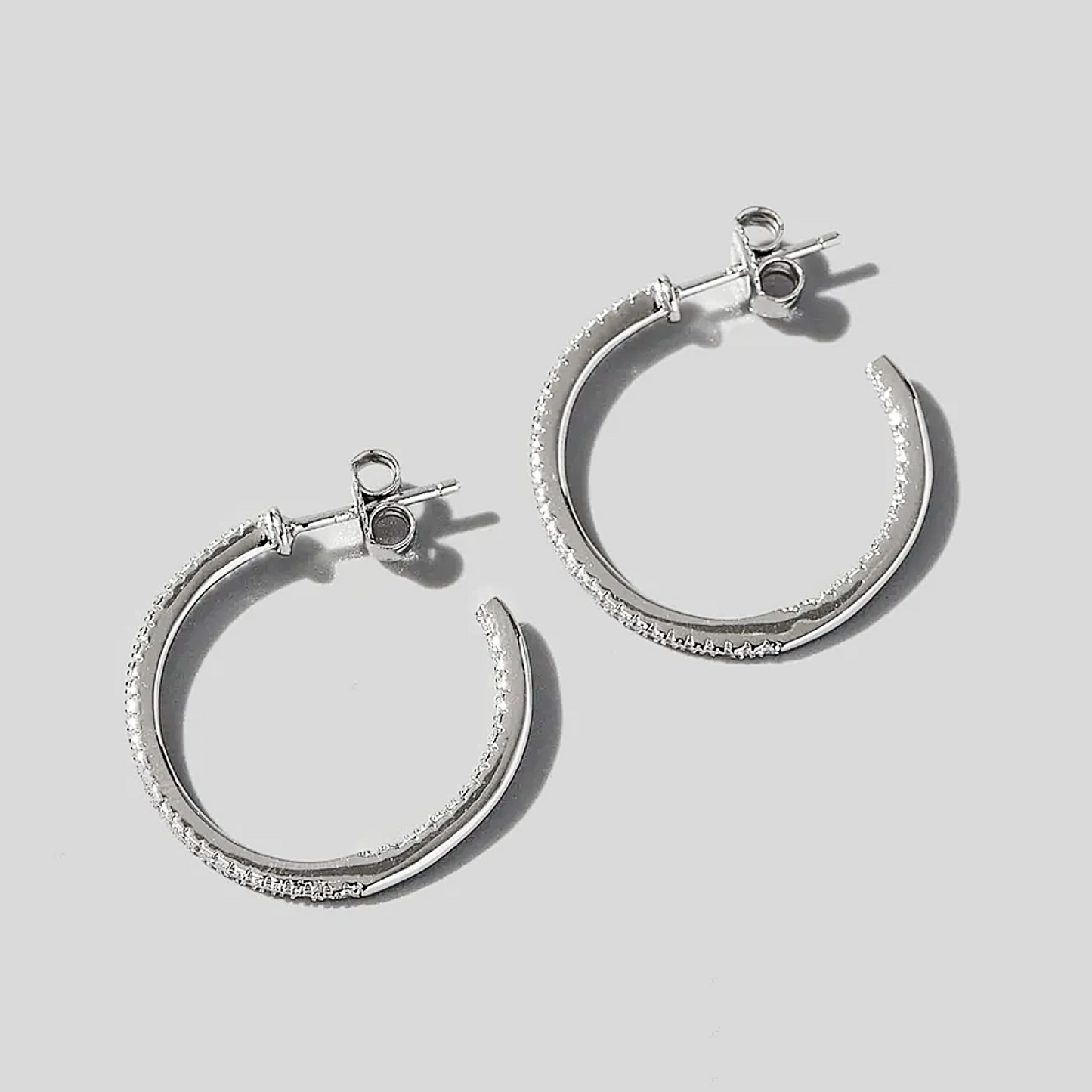 Silver hoop earrings on a light gray background