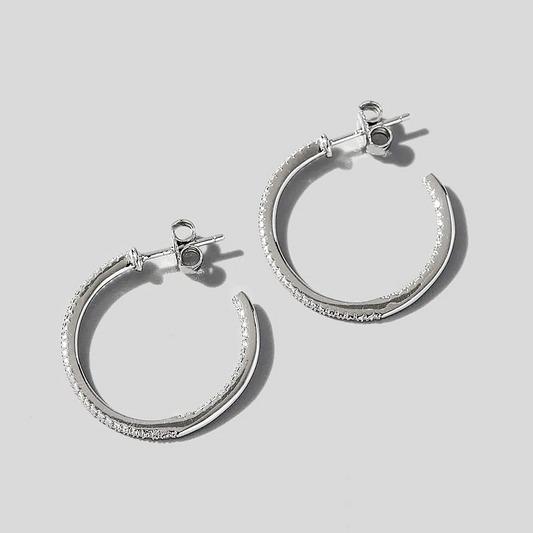 Silver hoop earrings on a light gray background