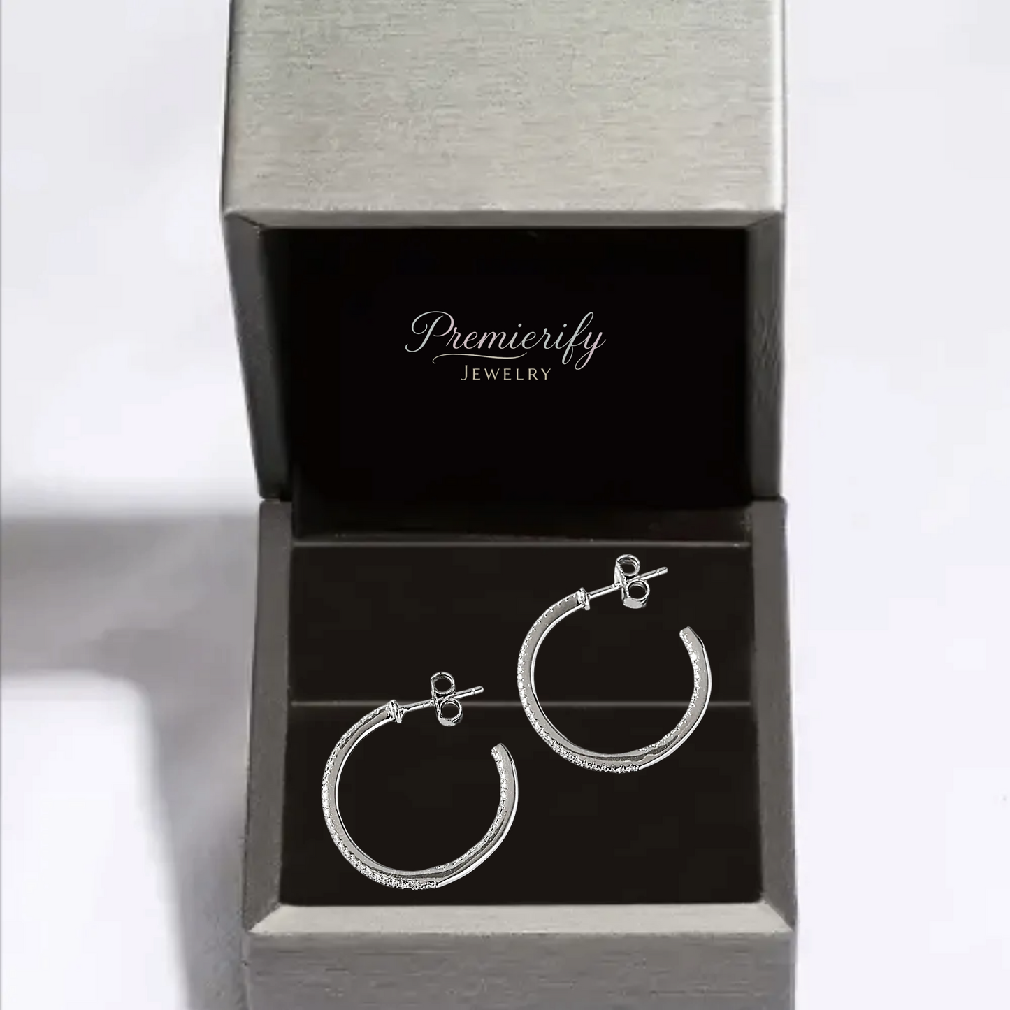 Silver hoop earrings in an open Premierify Jewelry box on a white background